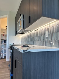 a kitchen with black cabinets and a microwave